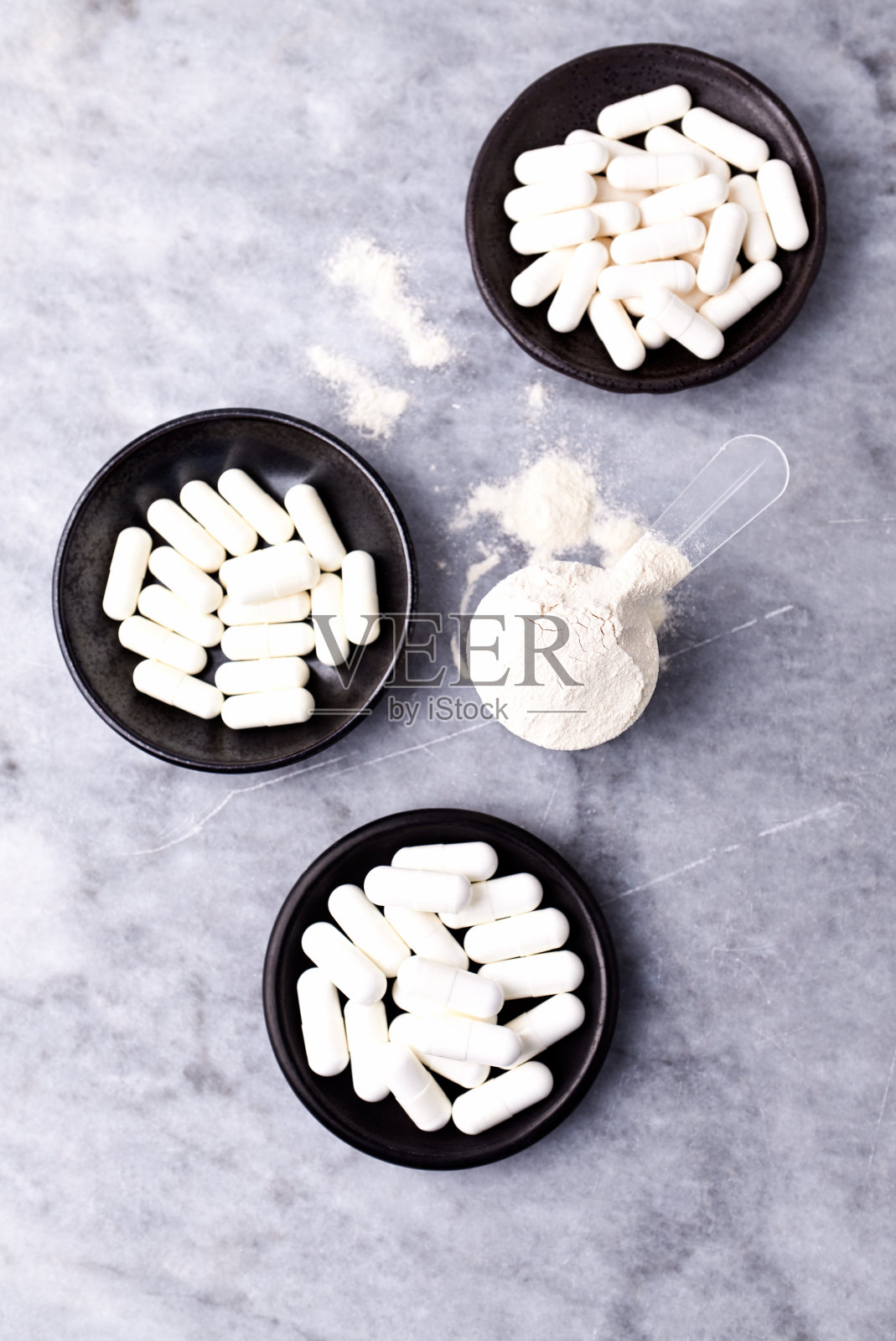 乳清蛋白,水解膠原I型,l -脯氨酸和l -賴氨酸膠囊勺。補(bǔ)充膠原蛋白的生產(chǎn)。明亮的石頭背景。直接上圖。副本的空間。